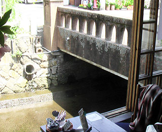 写真は草画房の窓際にあるカフェテーブル。すぐ下には川が流れている