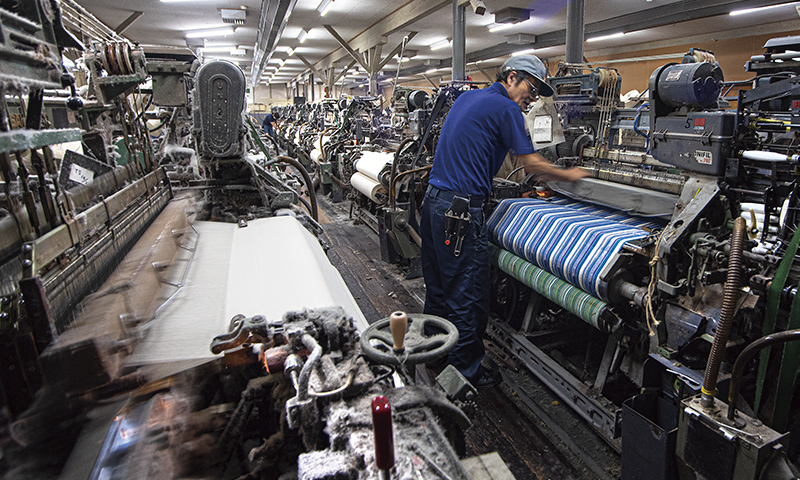 工場では、生糸と先染め糸を用いたストライプの生地も織り上げている。柄の出方や糸と糸が絡まっていないか、熟練スタッフが入念にチェックしている。