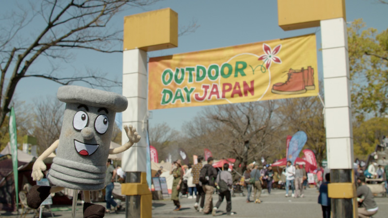 カートピアのキャラクター、ボルトちゃんがアウトドアデイジャパン東京の入口でポーズを決めている様子 | SUBARU