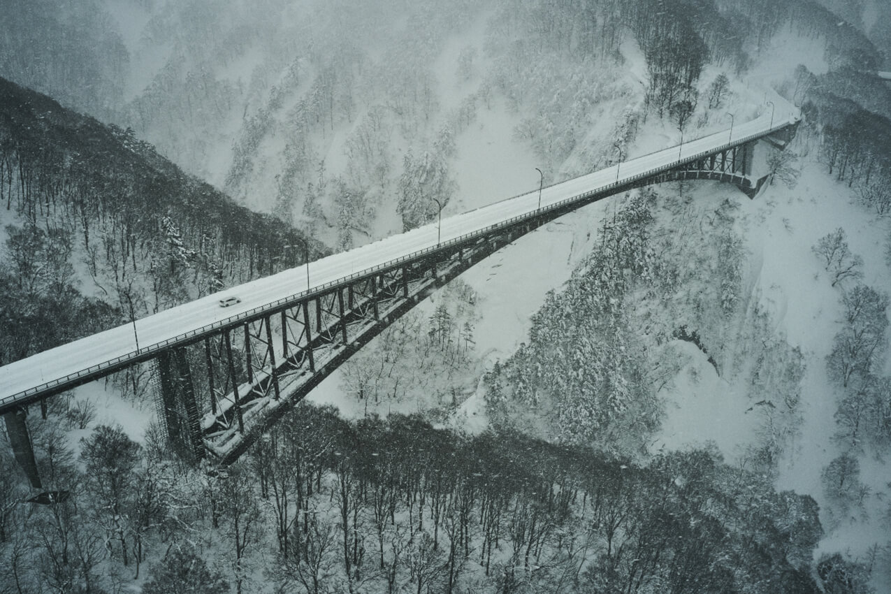 青森県 雪で覆われた城ヶ倉大橋を走るレヴォーグ(クリスタルホワイトパール) | SUBARU グランドツーリングNIPPON