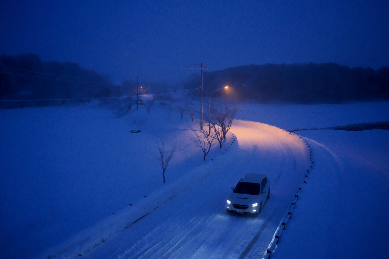 青森県 夜明け前の雪道を走るレヴォーグ(クリスタルホワイトパール) | SUBARU グランドツーリングNIPPON