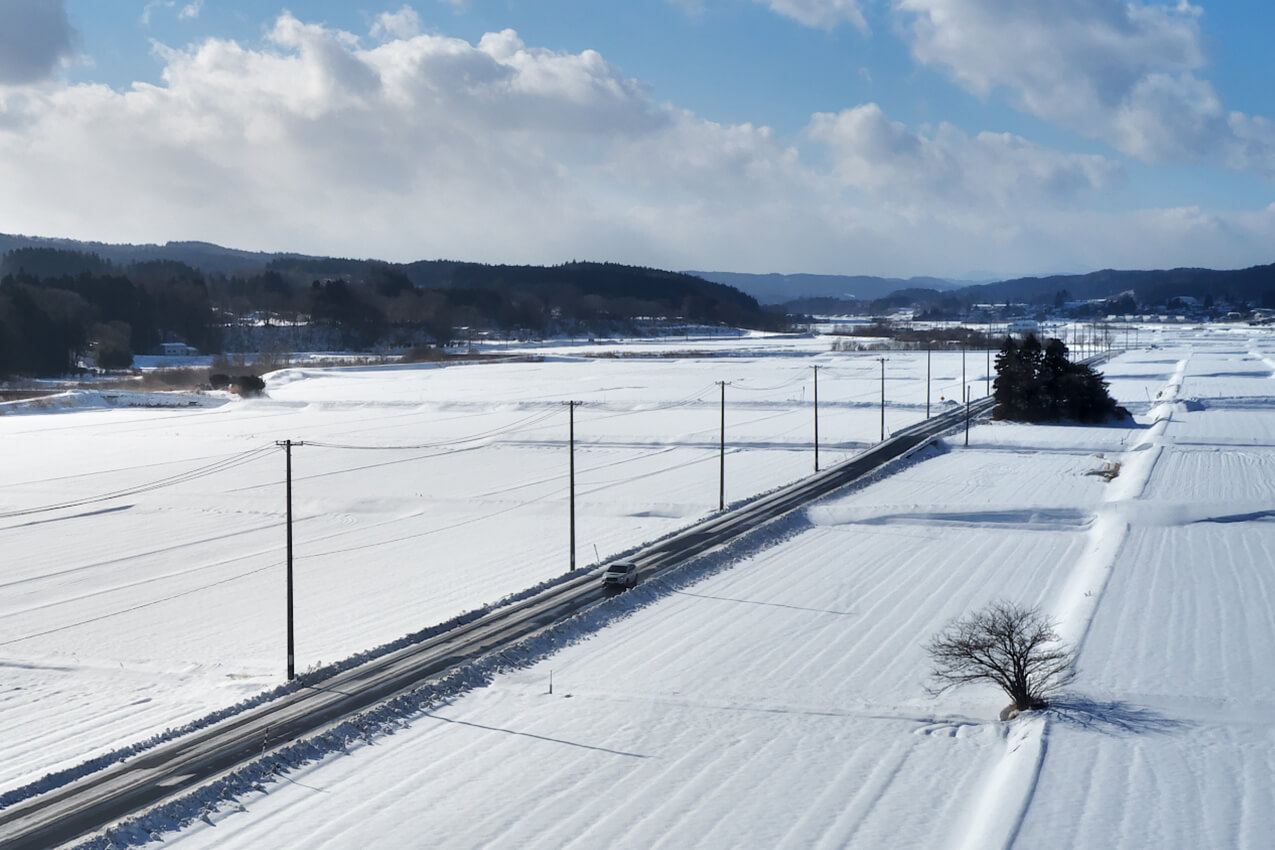 青森県 雪化粧された田園を走るレヴォーグ(クリスタルホワイトパール) | SUBARU グランドツーリングNIPPON