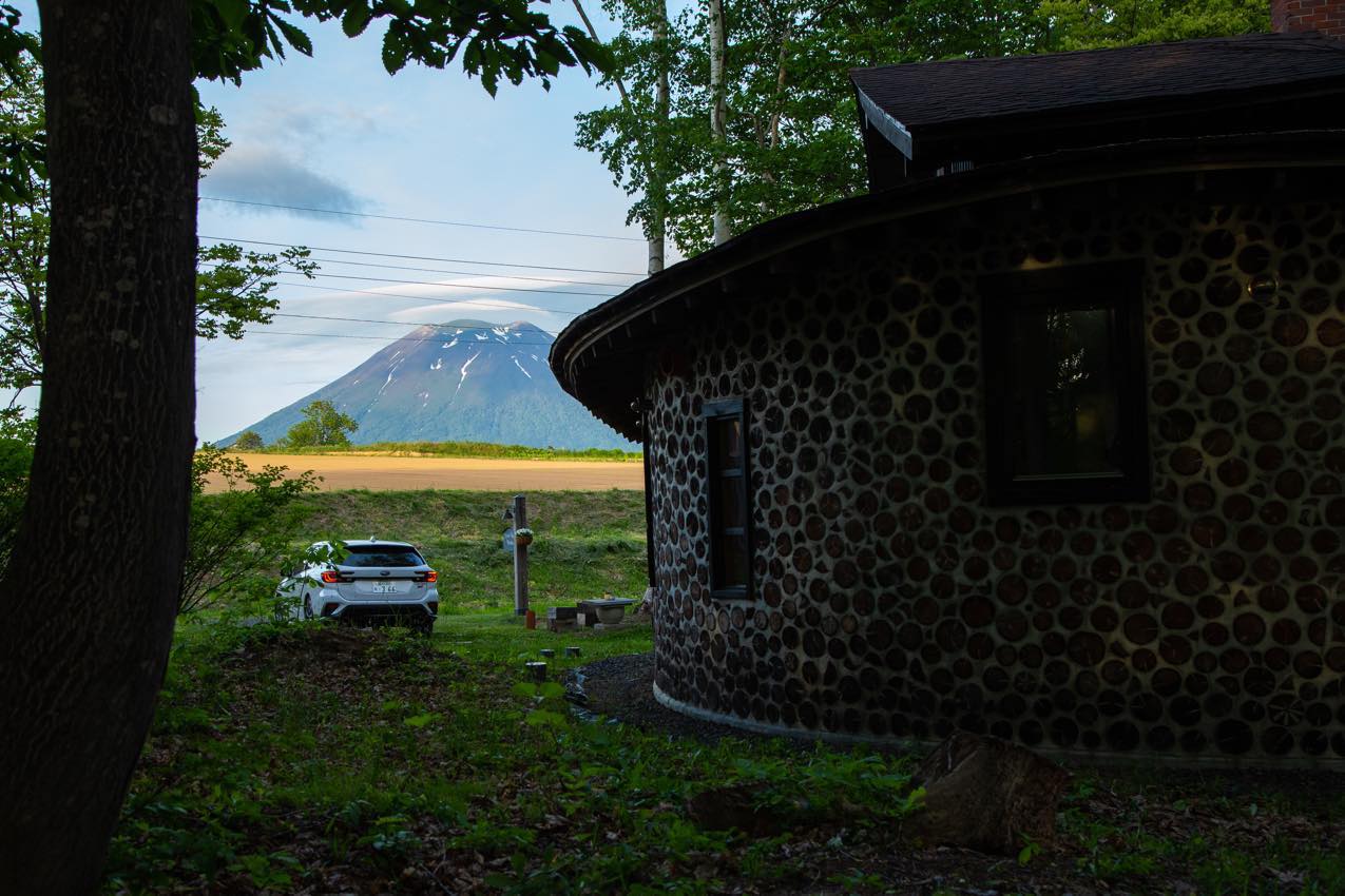 北海道 Tree Shell Nisekoの側に停まるレヴォーグと隙間から見える羊蹄山 | SUBARU グランドツーリングNIPPON