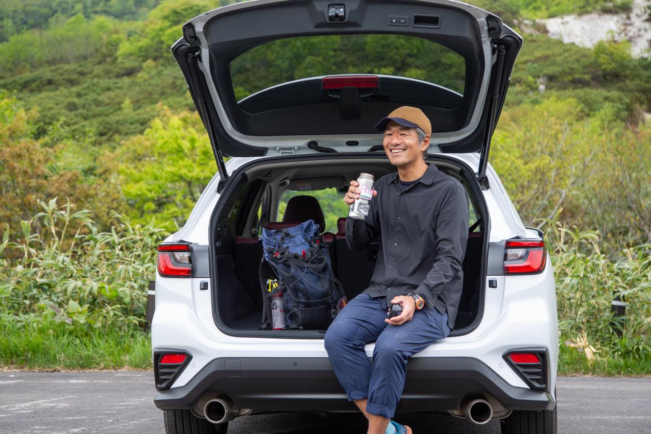 北海道 レヴォーグ（セラミックホワイト）のトランクに腰をかけ休息を取る峠ヶさん | SUBARU グランドツーリングNIPPON