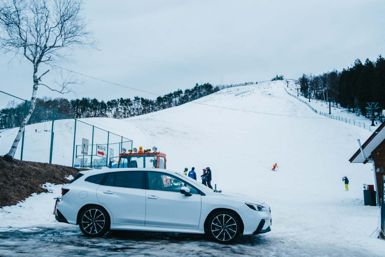長野県 聖高原スキー場の駐車場に停まるレヴォーグ（セラミックホワイト）とすぐ奥に隣接するゲレンデ | SUBARU グランドツーリングNIPPON | SUBARU | レヴォーグ