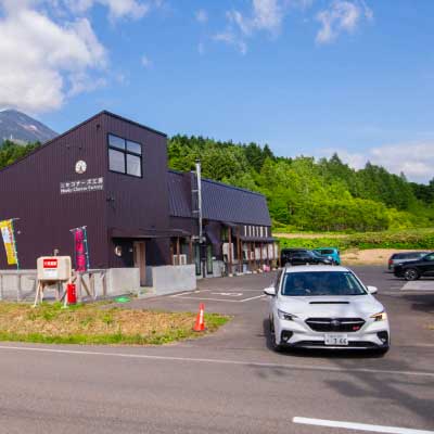 北海道 ニセコチーズ工房の駐車場から出るレヴォーグ | SUBARU グランドツーリングNIPPON