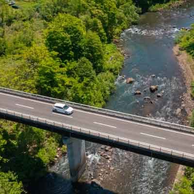 北海道 ニセコの渓流に架かる橋を走るレヴォーグ | SUBARU グランドツーリングNIPPON