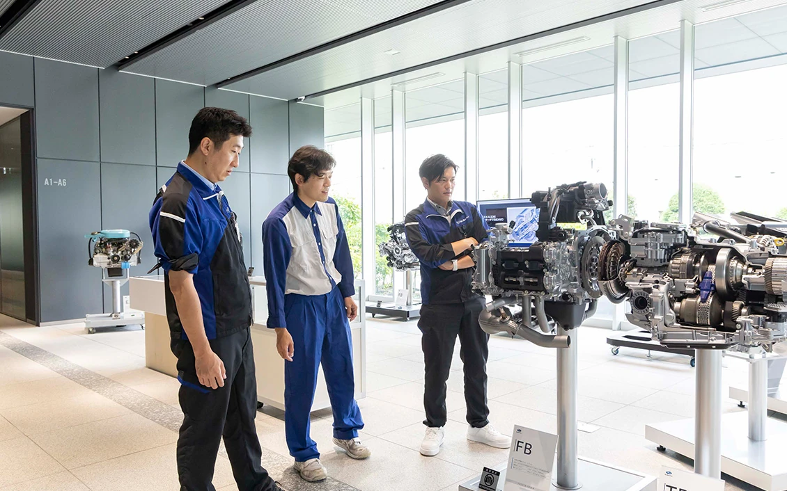 歴代のエンジンを前に談笑する3人