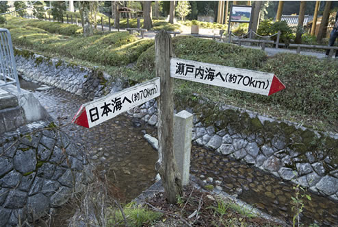 写真はスバルの月刊誌カートピア2月号で訪れた兵庫県丹羽市氷上町石生にある中央分水界。水が日本海側と太平洋側に分かれる矢印。