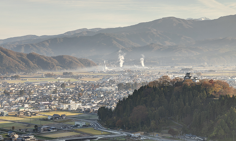 「撮影スポット」から眺めた福井県大野市の風景。手前の小高い山が亀山。その上に越前大野城の天守（1968年再建）が見える。