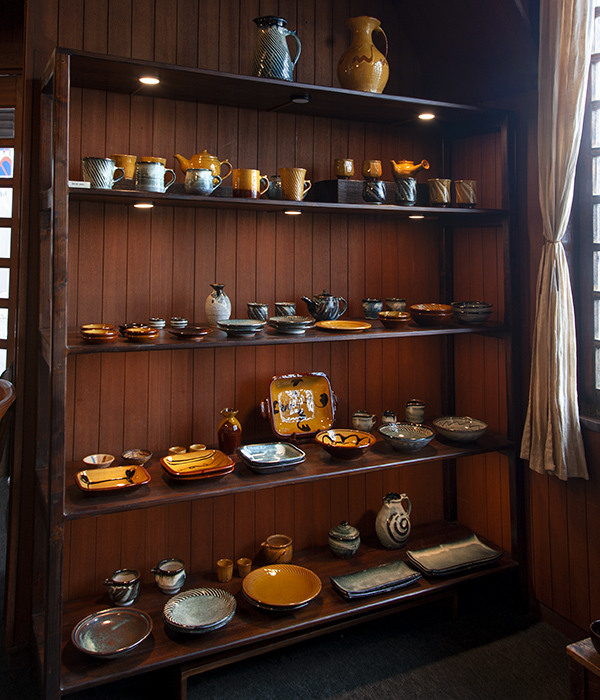 彩りにあふれた湯町窯の陶器が並ぶ棚。