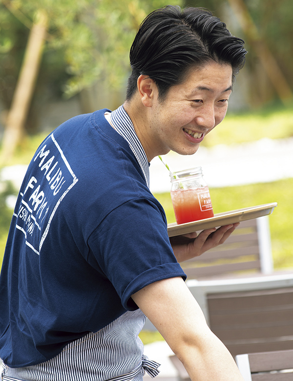 ロゴ入りTシャツで接客するマネージャーの小荒井慶さん。