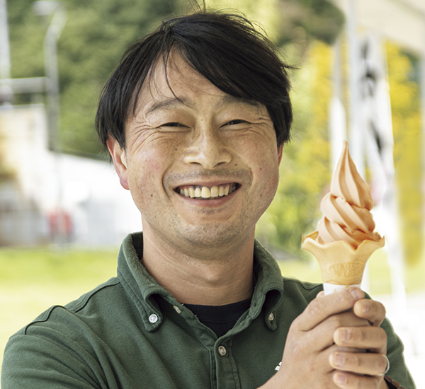駅長の星野重雄さんが手にするのはトマトソフトクリーム350円。