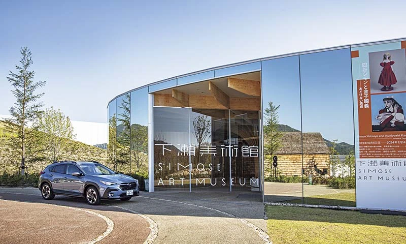 カートピア 建物の壁面が鏡になっており、周りの景色が反射して写っている下瀬美術館のエントランス | SUBARU
