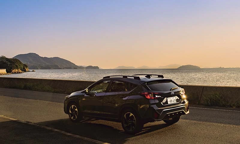 カートピア 夕暮れ時の海沿いを走るクロストレック | SUBARU