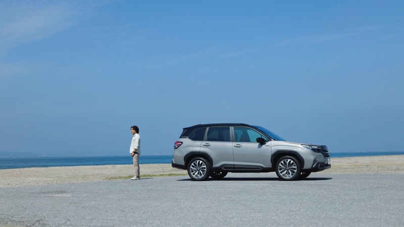 カートピア 富津海水浴場の海岸に佇むジャーナリスト・島下泰久と新型フォレスターPremium S:HEV EX | SUBARU