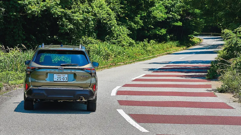 カートピア 山道を走る新型フォレスターX-BREAK S:HEV EX（オータムグリーン・メタリック）をリヤから見た様子 | SUBARU