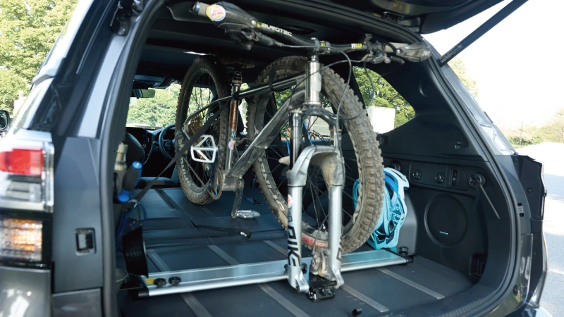 カートピア SUBARU純正アクセサリーのサイクルボードを使用し、SUVの荷室にマウンテンバイクを固定して積載しているシーン | SUBARU