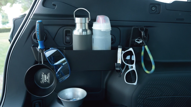 カートピア フォレスター専用のSUBARU純正アクセサリー、カーゴサイドストレージをカーゴルームに取り付けて、さまざまなアイテムを収納しているシーン | SUBARU