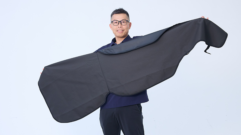 カートピア オールウェザーシートカバーを広げる大家敏宏さん | SUBARU