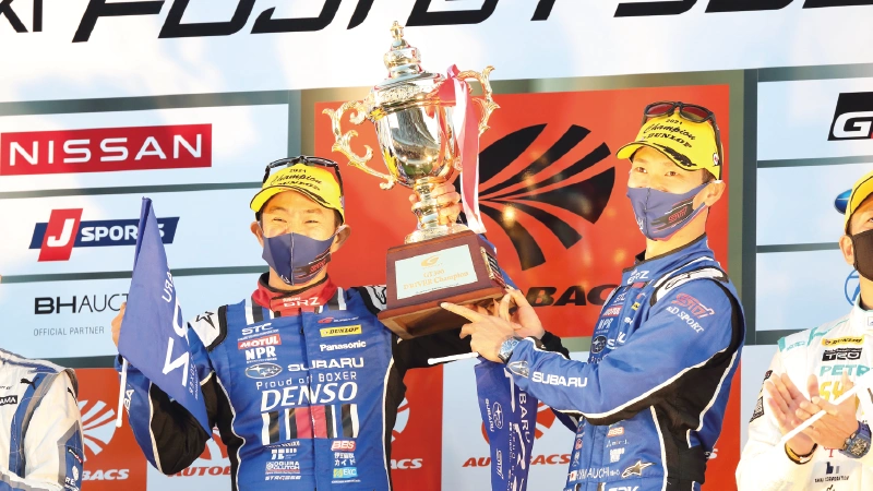 カートピア 優勝トロフィーを掲げるドライバーの山内英輝選手、井口卓人選手。 | SUBARU