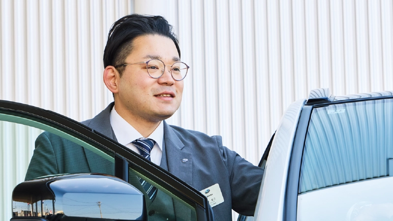 カートピア ソルテラ(ボディーカラーはプラチナホワイトパールマイカ)に乗り込む静岡スバルのセールス・青島さん。 | SUBARU