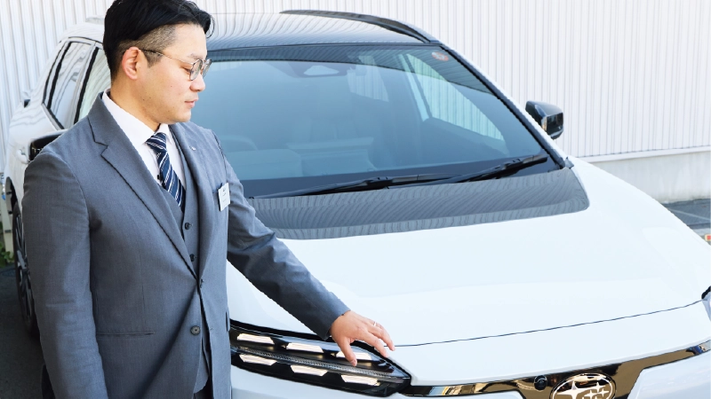 カートピア ソルテラの6連LEDデイライトに触れる静岡スバルのセールス・青島さん。 | SUBARU