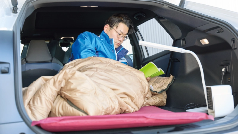 カートピア ソルテラのラゲッジスペースでくつろぐ静岡スバルのセールス・青島さん。 | SUBARU