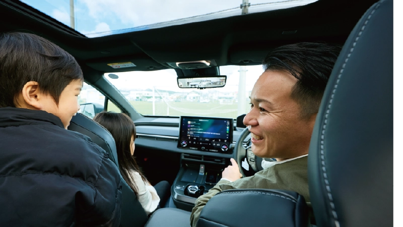 カートピア ソルテラの運転席から、後部座席にいる小さな息子に話しかける中山さん。助手席には小学生の娘が座っている。 | SUBARU