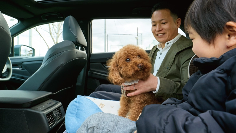 カートピア ソルテラの後部座席に座る、中山さんと息子。間には愛犬のトイプードルを座らせている。 | SUBARU