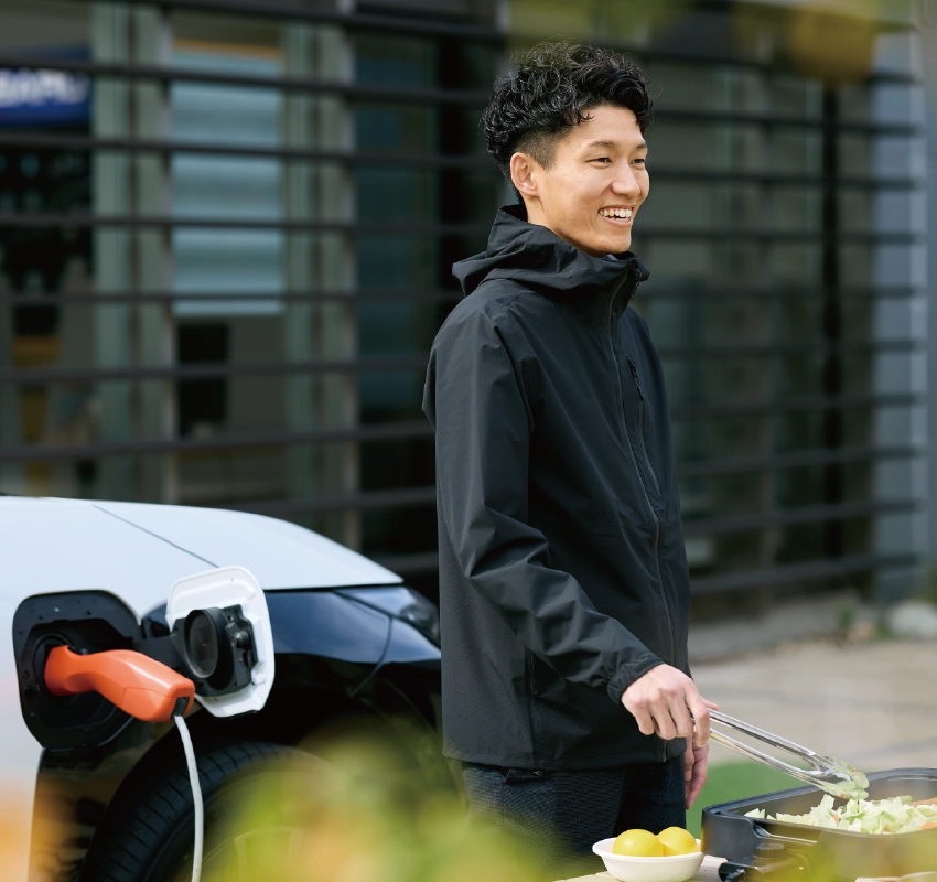 カートピア ソルテラの側でホットプレートを使い、バーベキューをする中山さん。 | SUBARU