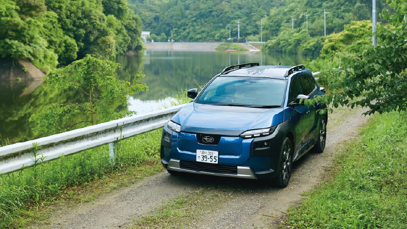 カートピア 緑に囲まれた湖畔の道を走るデイブレイクブルー・パールのトレイルシーカー。 | SUBARU