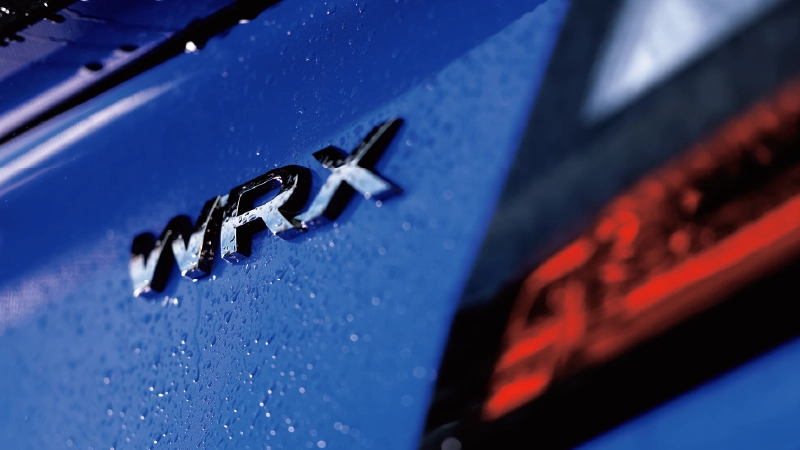 カートピア 青い車体に付いたWRXのエンブレム。右側に赤いテールランプが見える。 | SUBARU