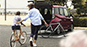 PHOTO：カスタムRS スマートアシスト（2WD）　ファイアークォーツレッド・メタリック　イメージ写真右側の自転車は、TOKYOBIKEの提供です。　写真はイメージです。撮影用の小物は商品には含まれません。